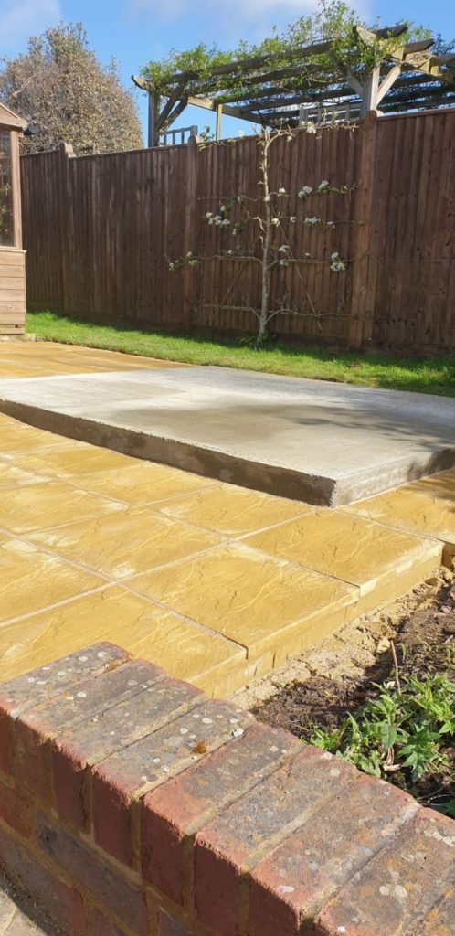 Finished-yellow-stone-patio-next-to-greenhouse