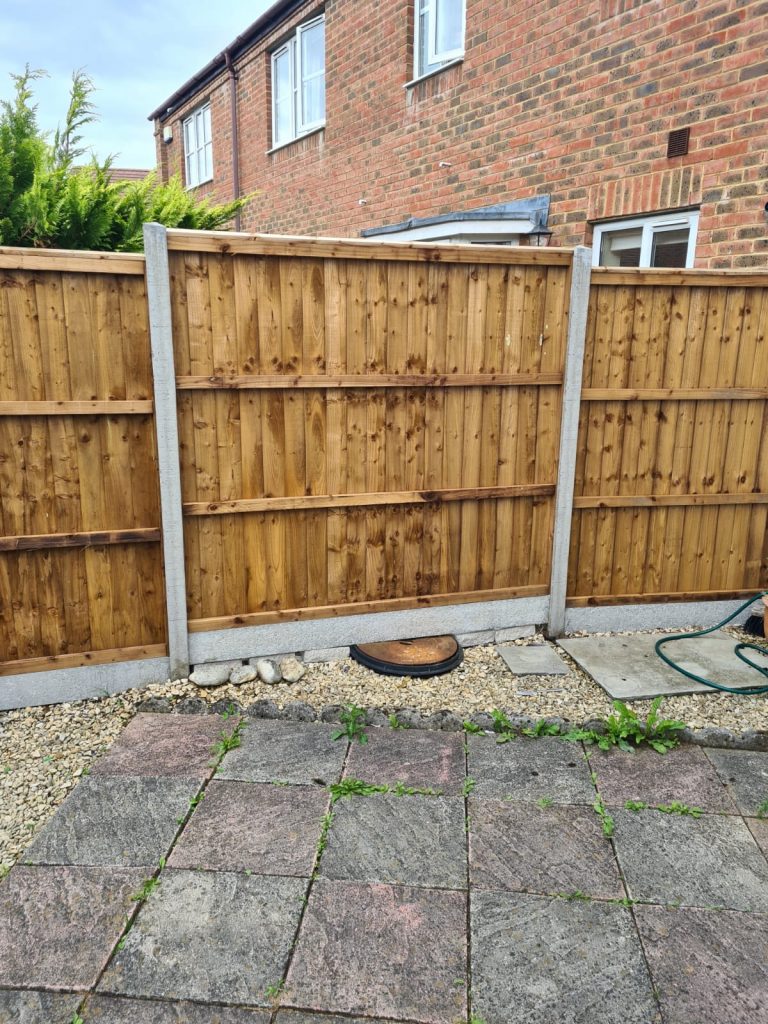 wooden-fence-and-patio-with-weeds